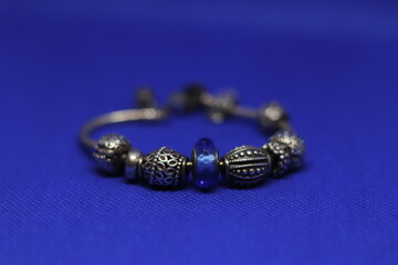 Beautiful silver bracelet on blue background
