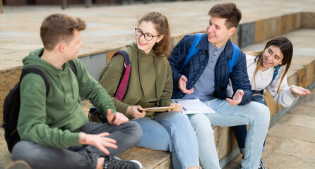 Four teenagers are talking about play on walk on the street