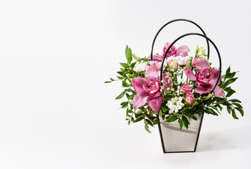 delicate orchids in a gift box or basket on a light background. bouquet of orchids, roses and chrysanthemums.