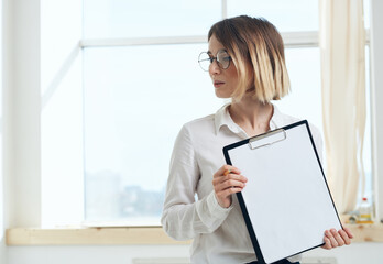 Woman rooming near window interior Folder with documents white sheet of paper 