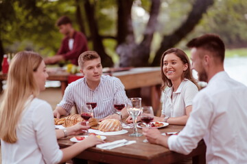 Fototapeta premium friends having picnic french dinner party outdoor during summer holiday