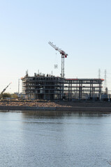 Industrial building under construction by lake bank