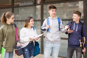 Teenagers students of middle school chatting and spending happy time together outside