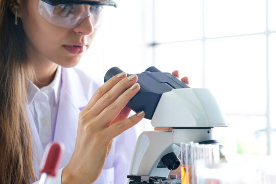 Cientist, she looks through the camera to see the details and Experiments with chemicals in the laboratory to create a vaccine for the treatment of diseases.soft focus