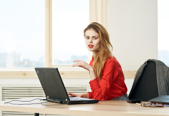 Woman secretary red shirt work desk laptop office manager