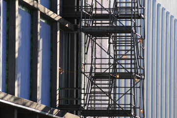 Fototapeta premium Exterior scaffolding installed along commercial building under construction, showing framing, insulation, and facade preparation in modern urban development