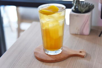 Peach tea with ice served on the table.
