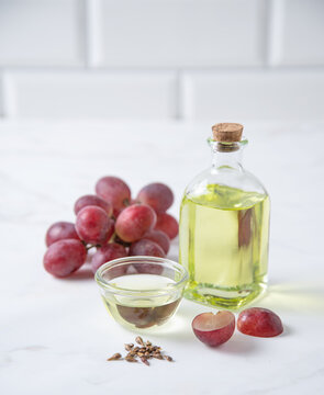 Natural vegetable oil from grape seeds in a clear bottle on the kitchen table. Dietary healthy food