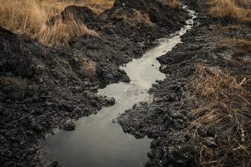 Autumn steppe landscape. Landscape in Kazakhstan. Kazakh steppe. Ditch with water. Water channel. Grunge steppe. Late Fall