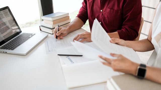 Young woman and man studying for a test or exam Tutor books with friends catching up and learning, education and school concept.