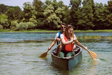 friends are canoeing in a wild river