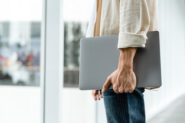 Man carrying his laptop while walking in the city