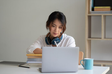 Young asian woman student study at home using laptop and learning online