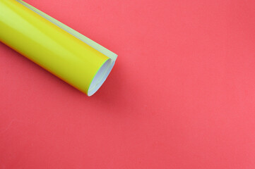 yellow colour paper over red background with copy space.