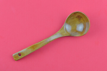 Wooden spoon over red background