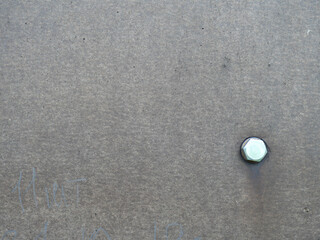 Gray texture of the building wall with a metal bolt. Close
