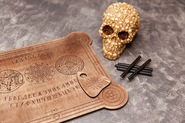 Talking spirit board and a skull, engulfed in mysterious and murky smoke. Talking board and...
