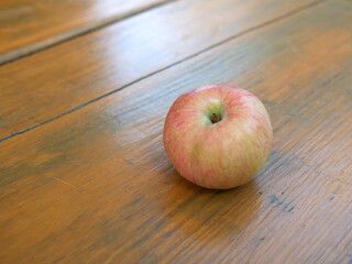 The apple is lying on the old wooden table table. A summer day. Copy space.