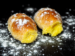 Close-up delicious cannoncino or puff pastry horn filled with custard. Traditional Italian food pastry. Black background