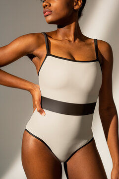 African American woman in white one-piece swimsuit with black stripe beach fashion