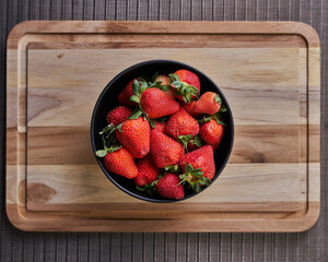 Fresas en un plato sobre una tabla listas para preparar un rico postre