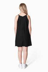 Blonde girl in black a-line dress for teenage summer apparel shoot rear view