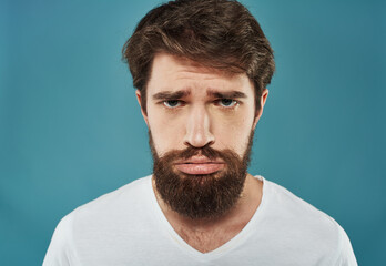 Fototapeta premium Man with a beard on a blue background portrait close-up