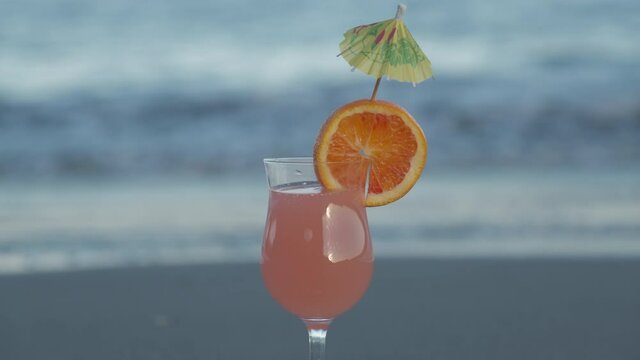 Cocktail drink with orange slice at the beach. tropical vacation, holiday appetizer