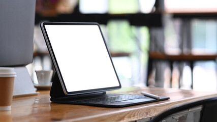 Close up view of computer tablet with blank screen on wooden table.