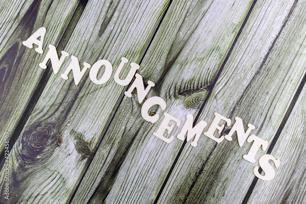 Fototapete announcements concept with a diagonal word of undulating alphabet letters on rustic wooden plank bac
