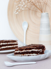 pieces of truffle cake with a cream layers on light background, elegant chocolate cake with mascarpone or curd filling