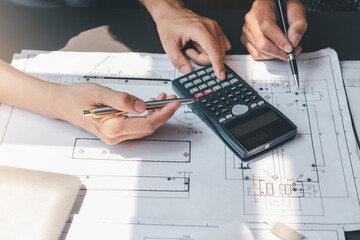 Architect man calculated the drafting using the blueprint calculator at the meeting.