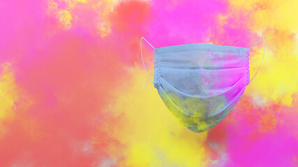 corona virus protective medical face mask in colorful smoke explosion Holi concept