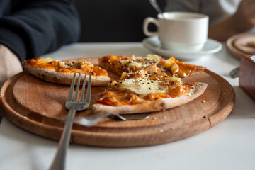 Hawaiian pizza on wooden board at party.