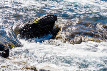 Creek or stream water flowing past rocks and stones
