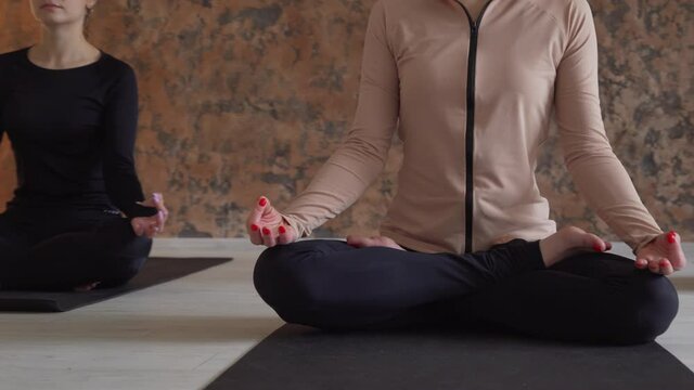 Three young handsome females sitting in studio and making meditation