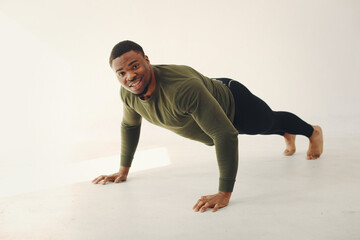 Handsome black man doing yoga on a white background