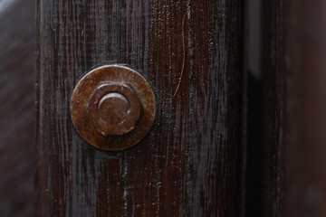 Nut bolt with macro look and blur in round wood with a dark brown wood look