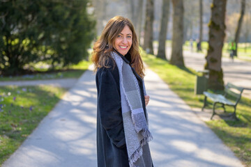 Happy vivacious woman stopping to look back at the camera