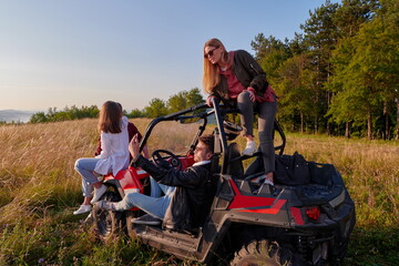 group young happy people enjoying beautiful sunny day while driving a off road buggy car