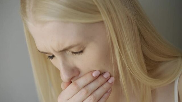 Close Up Of Woman Suffering With Cough.