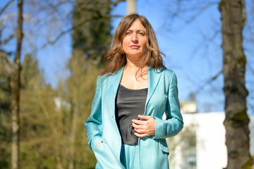 Stylish thoughtful woman in a low angle view walking in park