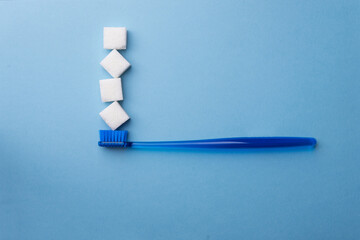 blue toothbrush with sugar cubes on a blue background