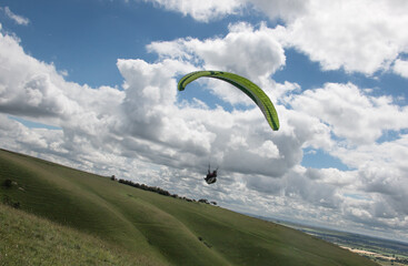 Lonely paraglider flying above English rural area