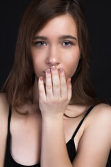 Young brown-haired woman, studio photo on black background