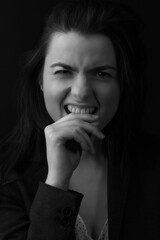 Black and white portrait of a young brunette woman in a studio on a black background