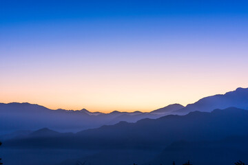 Obraz premium Layers of magnificent mountains with colorful clouds background at sunrise view