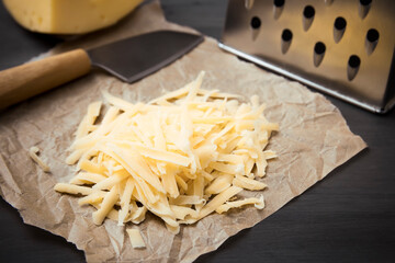 Fresh cheese on a parchment paper. On black background.