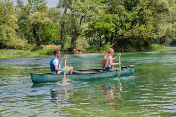Fototapeta na wymiar friends are canoeing in a wild river