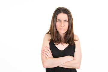 Portrait of sad angry woman standing with arms crossed aside blank copy space on white background